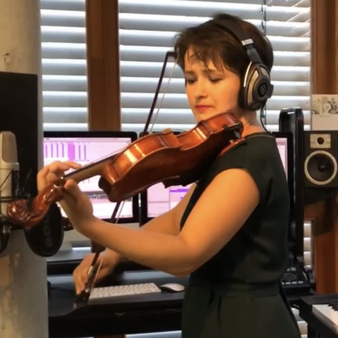 Valeria Gleim spielt mit Kopfhörern Violine im Aufnahmestudio