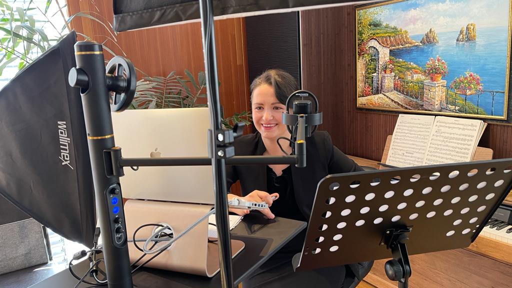 Valeria Gleim bei einer Online-Aufnahme mit Mikrofon, Notenpult und Laptop
